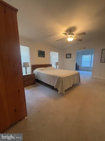 a spacious bedroom with a bed and a lamp