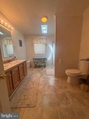 a spacious bathroom with a toilet a sink and mirror