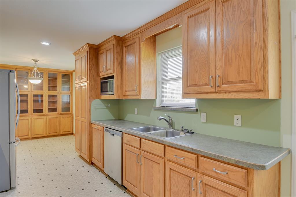 802 Cardinal Road Mansfield, TX 76063 - Photo 18 of 31 a kitchen with stainless steel appliances granite countertop a sink and cabinets with wooden floor