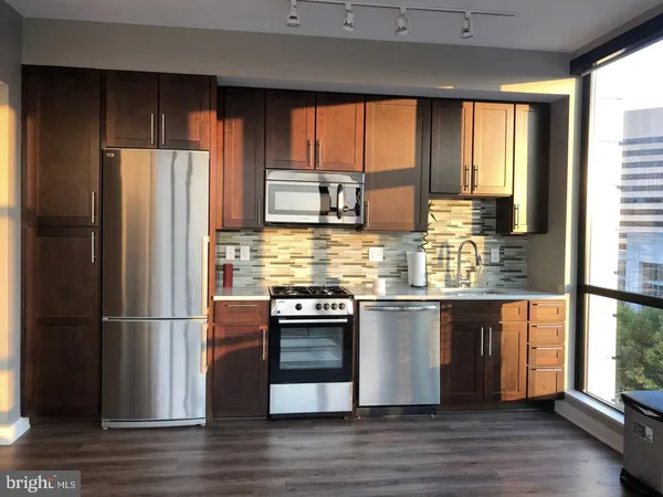a kitchen with stainless steel appliances granite countertop a refrigerator and wooden cabinets