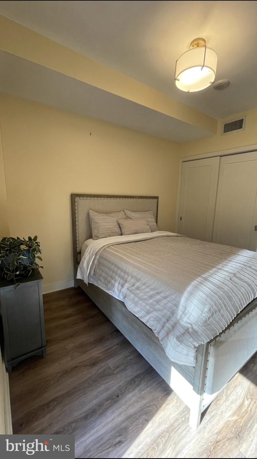 1320 Fenwick Lane, Unit 802 Silver Spring, MD 20910 - Photo 5 of 23 a bedroom with a bed and a chandelier