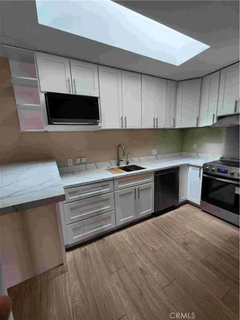 a kitchen with stainless steel appliances a stove a sink and a microwave
