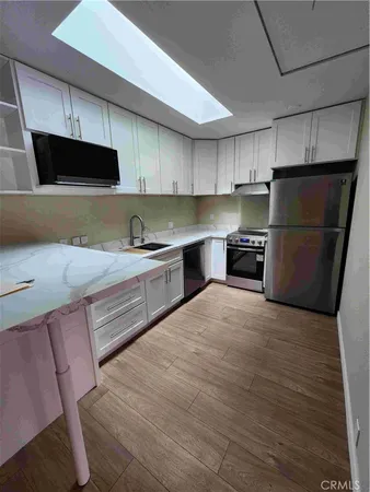 a kitchen with a sink a refrigerator and a stove top oven