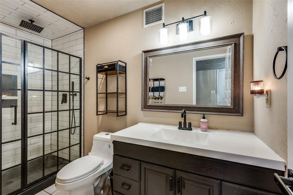 a bathroom with a sink toilet a mirror and shower