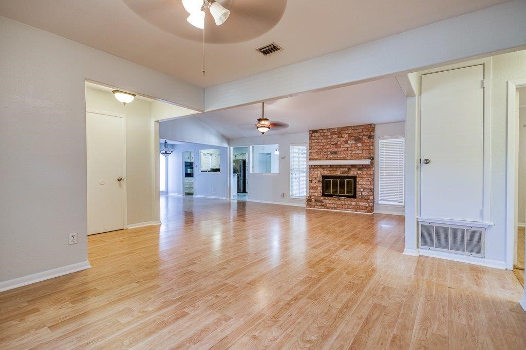 113 Seco Drive Portland, TX 78374 - Photo 6 of 37 a view of a livingroom with furniture a fireplace wooden floor and a kitchen