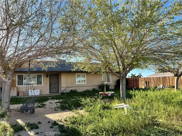 a front view of a house with a yard and potted plants