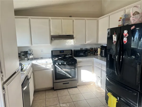 a kitchen with stainless steel appliances a stove a sink and a refrigerator