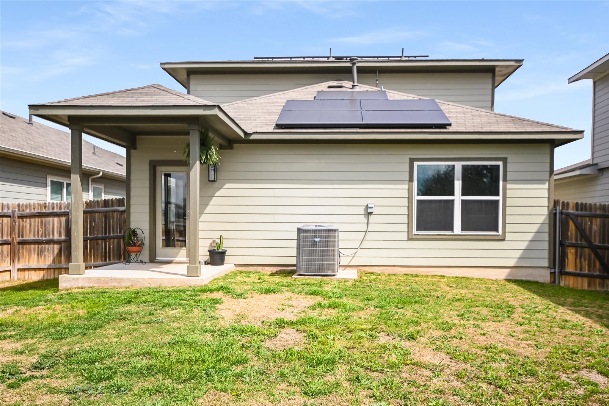 117 Deserti Road Leander, TX 78641 - Photo 20 of 21 Back of house featuring solar panels, a fenced backyard, a patio area, and a shingled roof