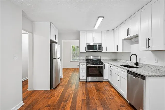 a kitchen with stainless steel appliances granite countertop a refrigerator a stove top oven a sink and dishwasher