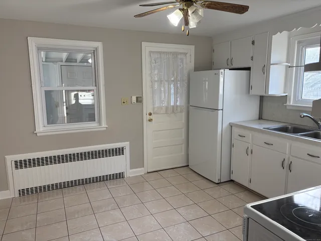 a kitchen with white cabinets and white appliances