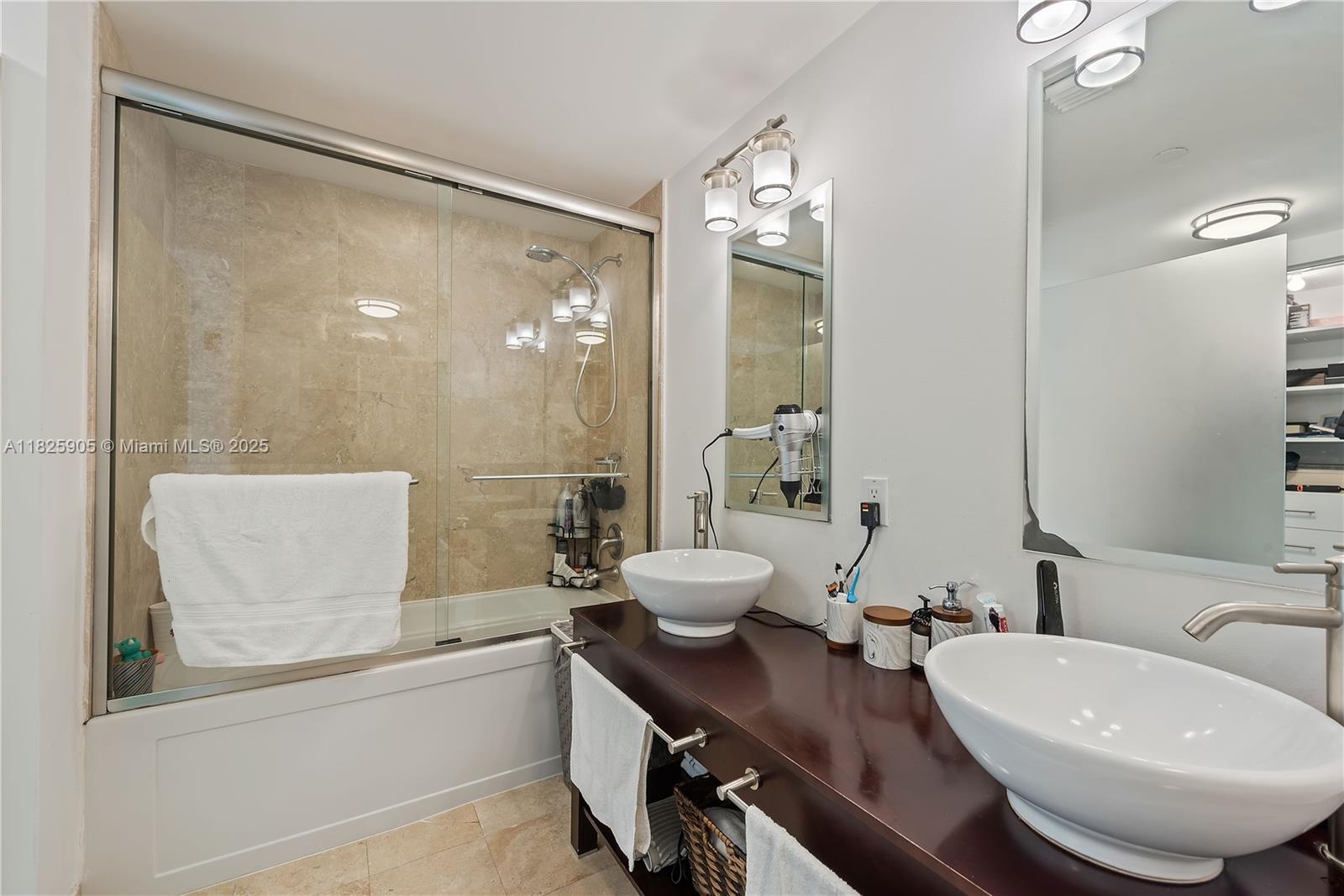 350 South Miami Avenue, Unit 1102 Miami, FL 33130 - Photo 13 of 29 a bathroom with a double vanity sink a toilet a mirror and shower