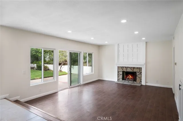 a view of an empty room with a fireplace and a window