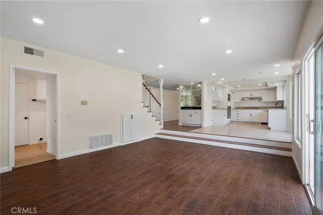 a view of kitchen with refrigerator and wooden floor