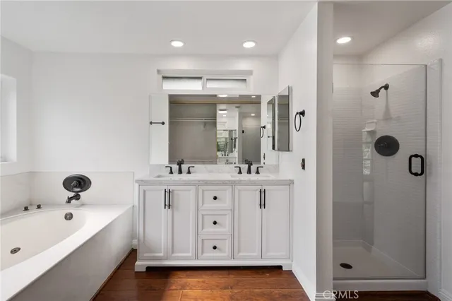 a bathroom with a tub a sink and mirrors