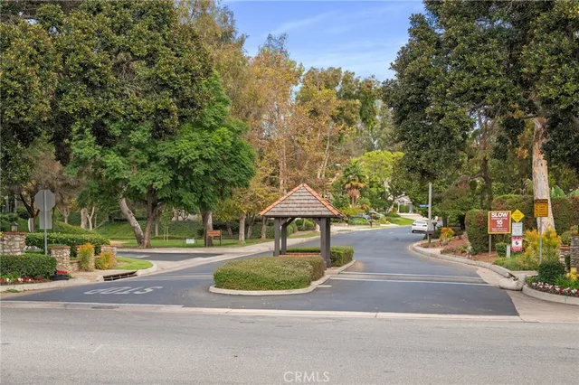 a front view of a house with a garden and trees