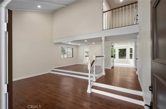 a view of a livingroom with wooden floor and stairs