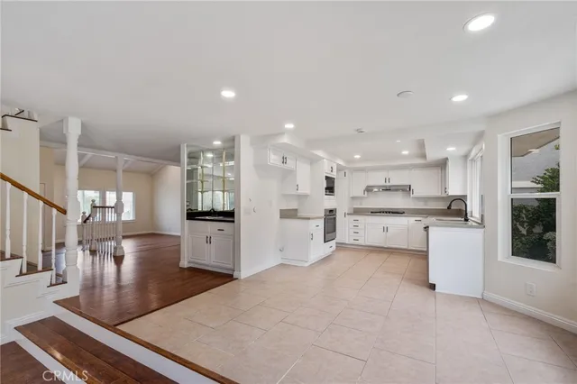a open kitchen with white cabinets and stainless steel appliances