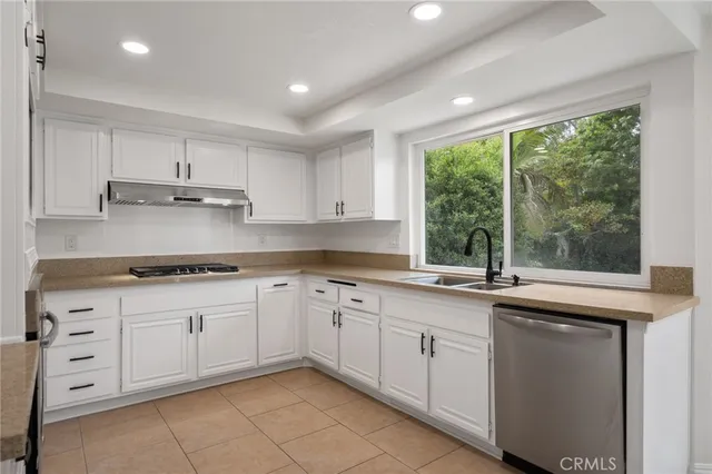 a kitchen with cabinets appliances a sink and a window