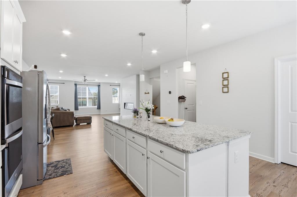 3535 Senna Road Duluth, GA 30096 - Photo 45 of 60 a hall with kitchen island a sink appliances and a counter top space