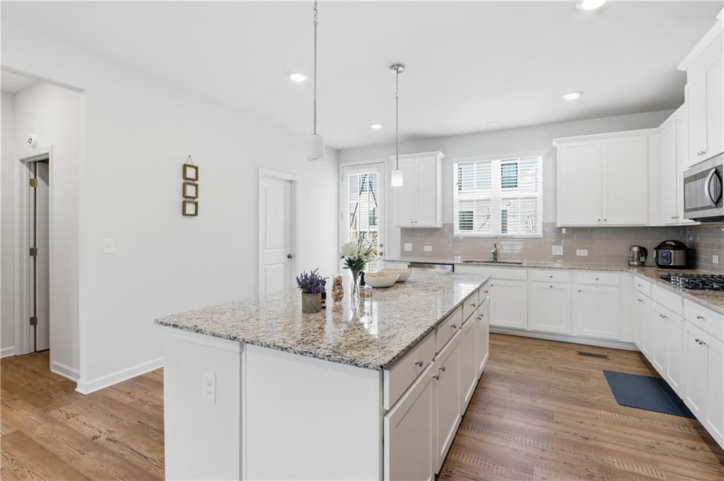 3535 Senna Road Duluth, GA 30096 - Photo 47 of 60 a large kitchen with granite countertop a sink a counter space appliances and cabinets