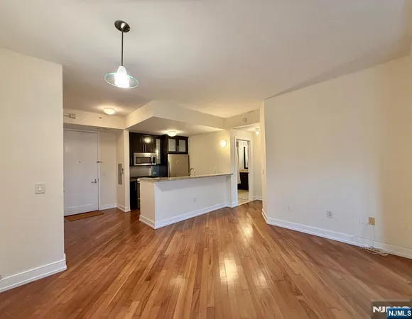 a view of a big room with wooden floor and windows
