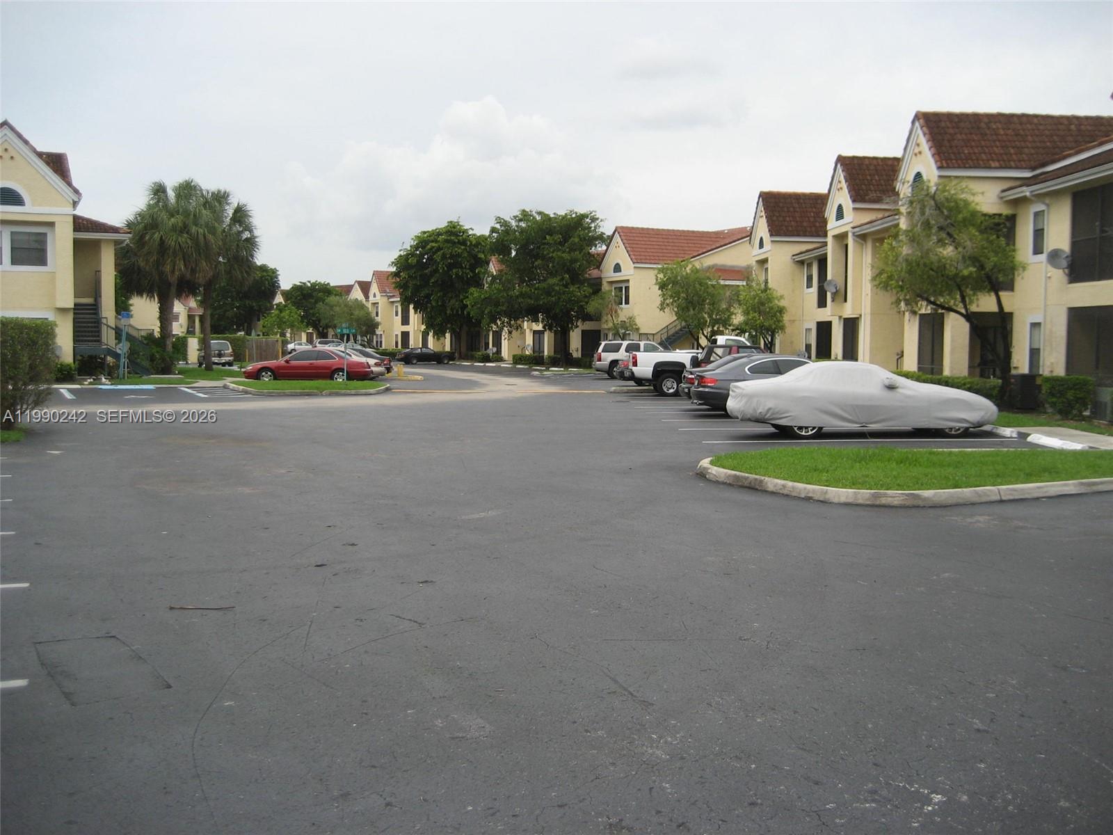15051 Southwest 103rd Lane, Unit 4103 Miami, FL 33196 - Photo 17 of 19 a couple of cars parked in front of a building