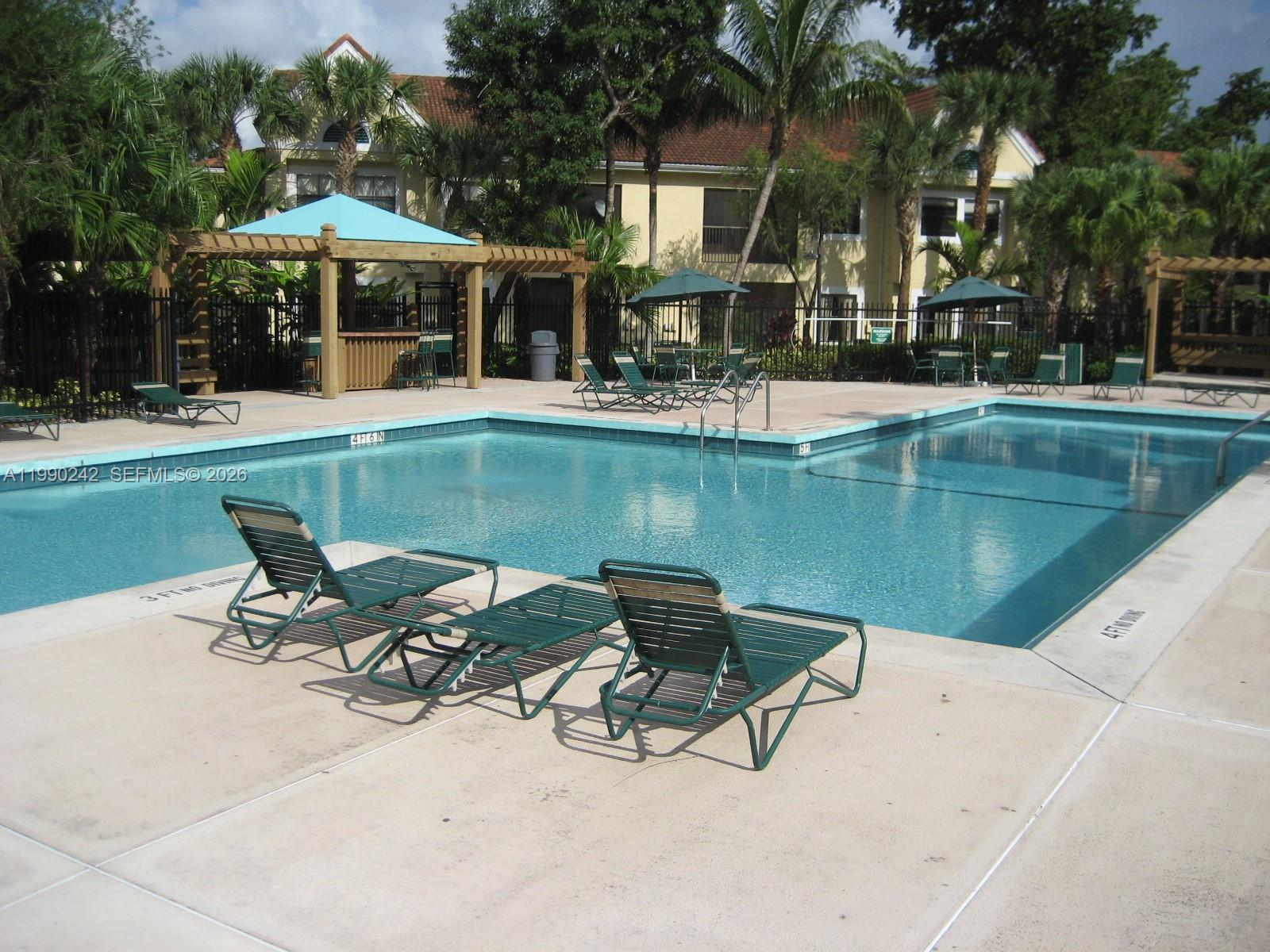 15051 Southwest 103rd Lane, Unit 4103 Miami, FL 33196 - Photo 18 of 19 a view of a lake with a table and chairs