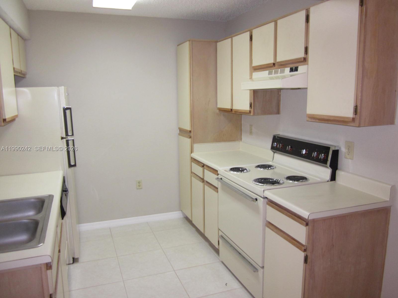 15051 Southwest 103rd Lane, Unit 4103 Miami, FL 33196 - Photo 3 of 19 a white kitchen with a stove top oven