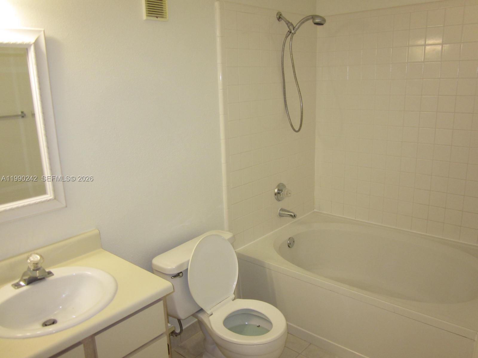 15051 Southwest 103rd Lane, Unit 4103 Miami, FL 33196 - Photo 6 of 19 a white bath tub sitting next to a white toilet and a sink