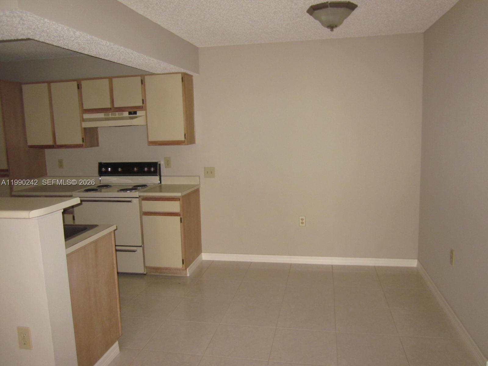 15051 Southwest 103rd Lane, Unit 4103 Miami, FL 33196 - Photo 9 of 19 a kitchen with white cabinets and white appliances
