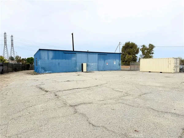 a view of a dry yard with wooden fence