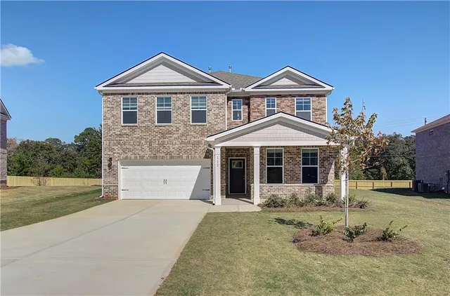 a front view of a house with a yard and garage