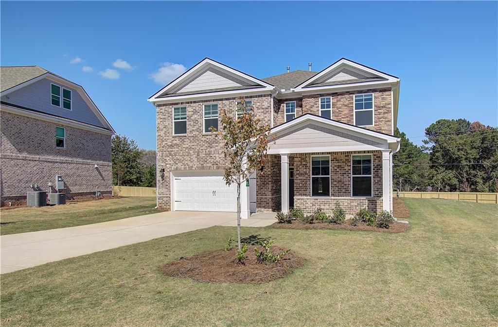 257 Chiswick Loop Stockbridge, GA 30281 - Photo 2 of 32 a front view of a house with a yard and garage