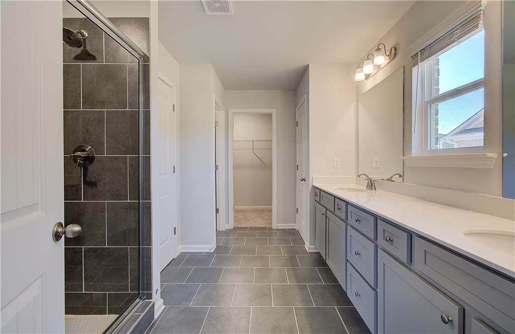 257 Chiswick Loop Stockbridge, GA 30281 - Photo 25 of 32 a bathroom with a double vanity sink a toilet and a shower