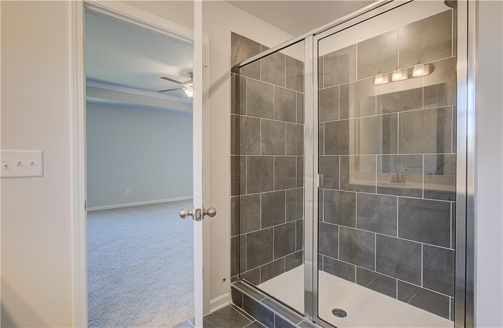 257 Chiswick Loop Stockbridge, GA 30281 - Photo 27 of 32 a bathroom with a glass shower door