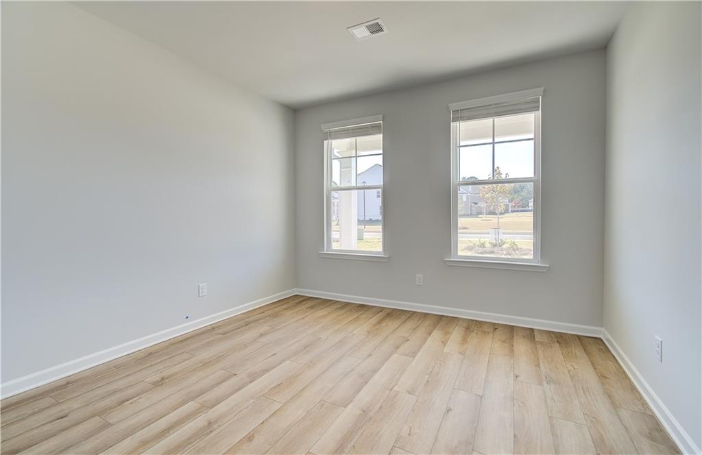 257 Chiswick Loop Stockbridge, GA 30281 - Photo 5 of 32 an empty room with wooden floor and windows