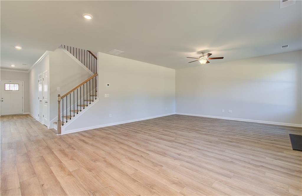 257 Chiswick Loop Stockbridge, GA 30281 - Photo 8 of 32 an empty room with wooden floor fan and windows