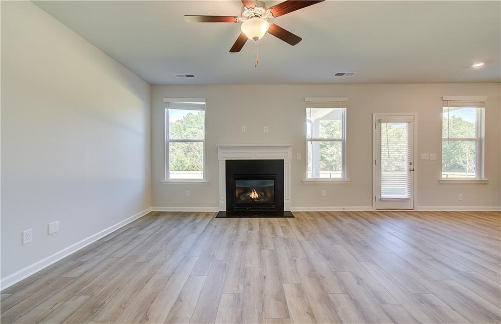 257 Chiswick Loop Stockbridge, GA 30281 - Photo 10 of 32 a view of an empty room with wooden floor fireplace and a window
