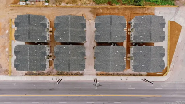 an aerial view of a house with a yard and lake view