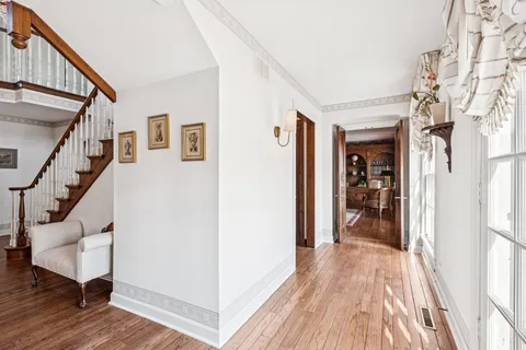 a view of a hallway with wooden floor and staircase