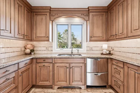 a dining room with furniture a chandelier and kitchen view