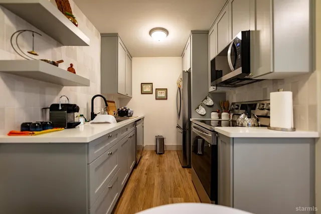 a kitchen with stainless steel appliances a sink stove and cabinets