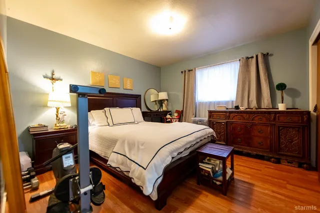 a bedroom with a bed and wooden floor