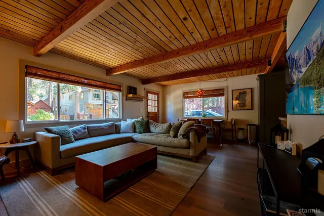 a living room with furniture a wooden floor and next to a window