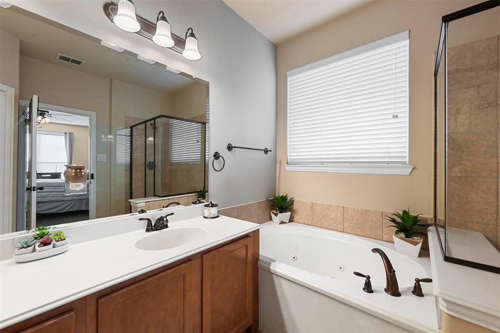 14815 Frisco Ranch Drive Little Elm, TX 75068 - Photo 18 of 40 a bathroom with a tub sink and mirror
