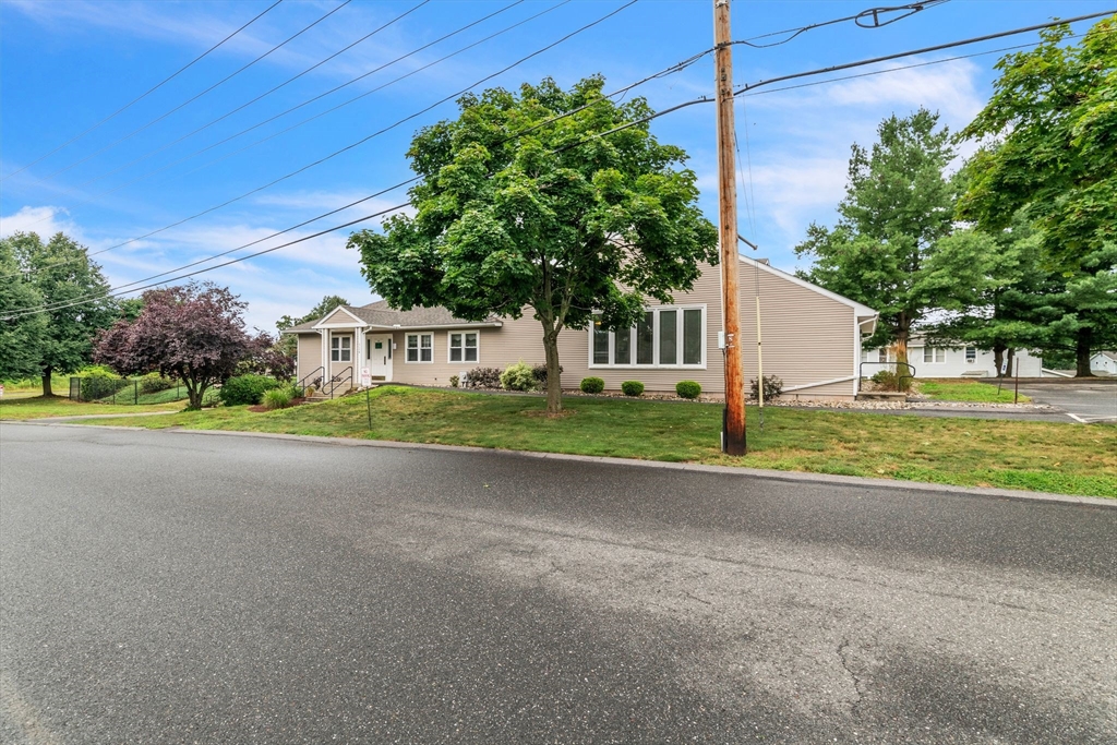 123 Outer Drive, Unit 123 Chicopee, MA 01022 - Photo 4 of 33 a front view of a house with a yard and garage