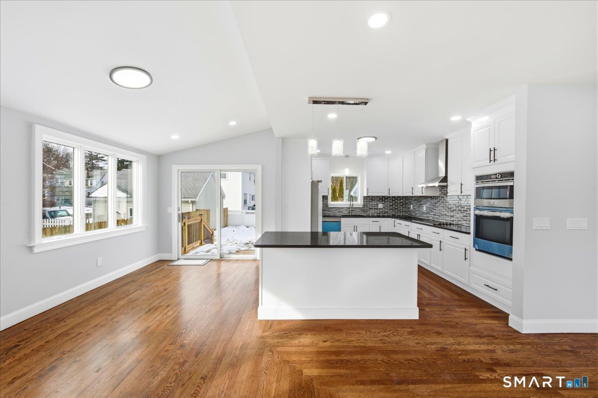 52 Coram Street Hamden, CT 06517 - Photo 14 of 40 a large kitchen with kitchen island a large counter top space a sink appliances and cabinets