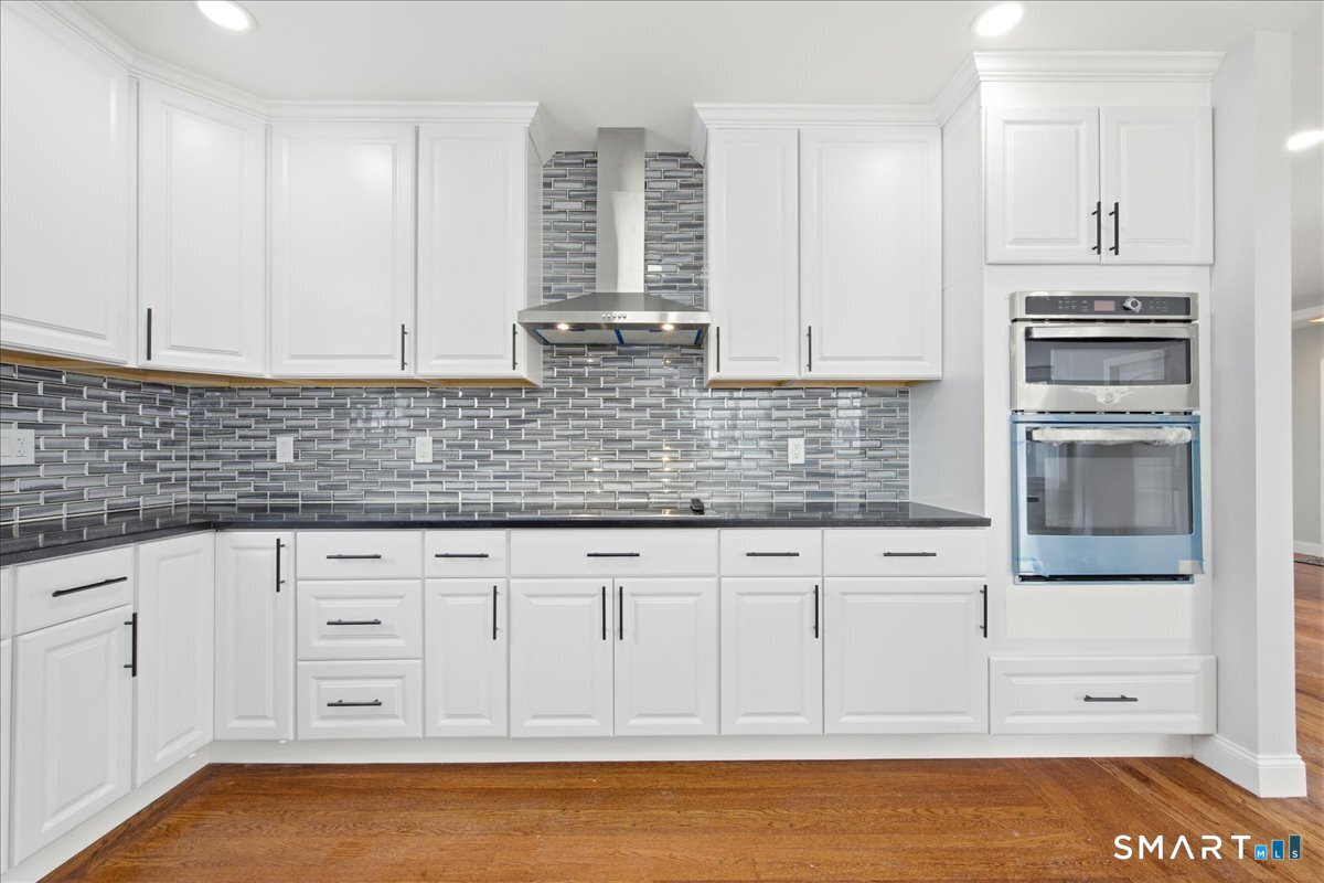 52 Coram Street Hamden, CT 06517 - Photo 17 of 40 a kitchen with granite countertop white cabinets and stainless steel appliances