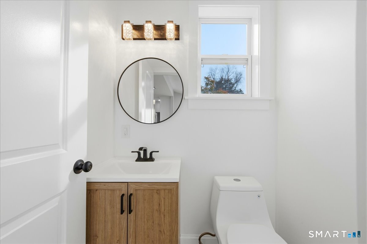 52 Coram Street Hamden, CT 06517 - Photo 20 of 40 a bathroom with a sink a toilet and a mirror
