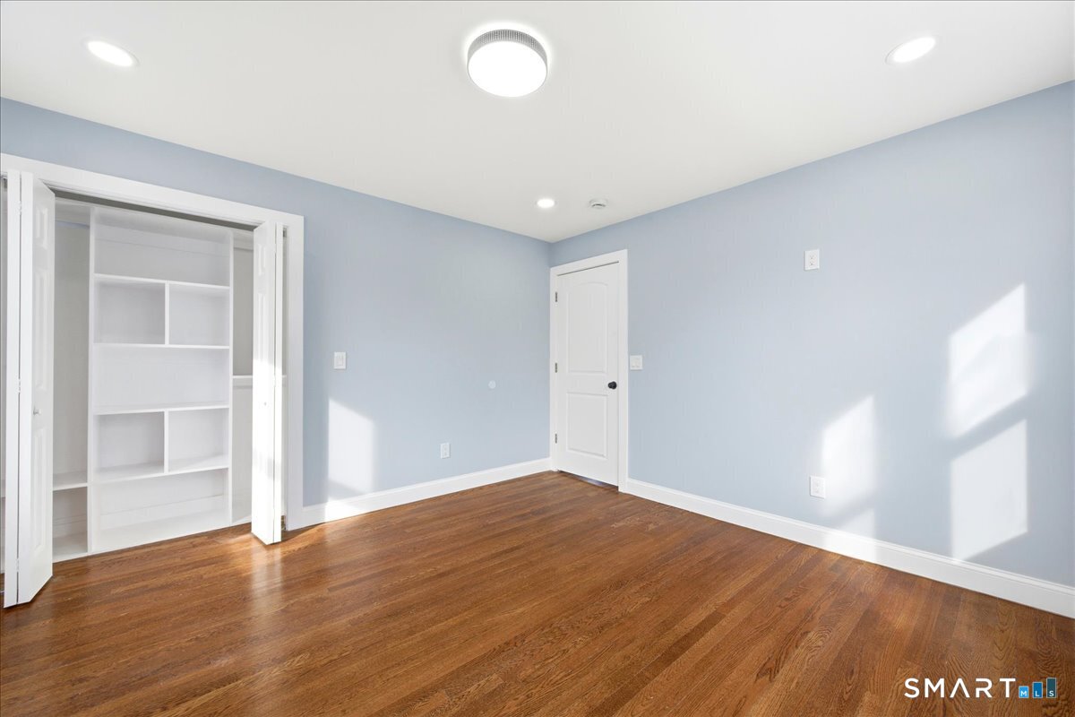 52 Coram Street Hamden, CT 06517 - Photo 27 of 40 an empty room with wooden floor and windows